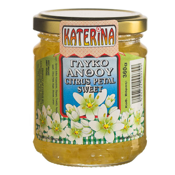 A glass jar of Katerina Citrus Petal Sweet, filled with golden-yellow citrus zest, featuring a colorful label with white citrus flowers and a gold metal lid, set against a plain white background.